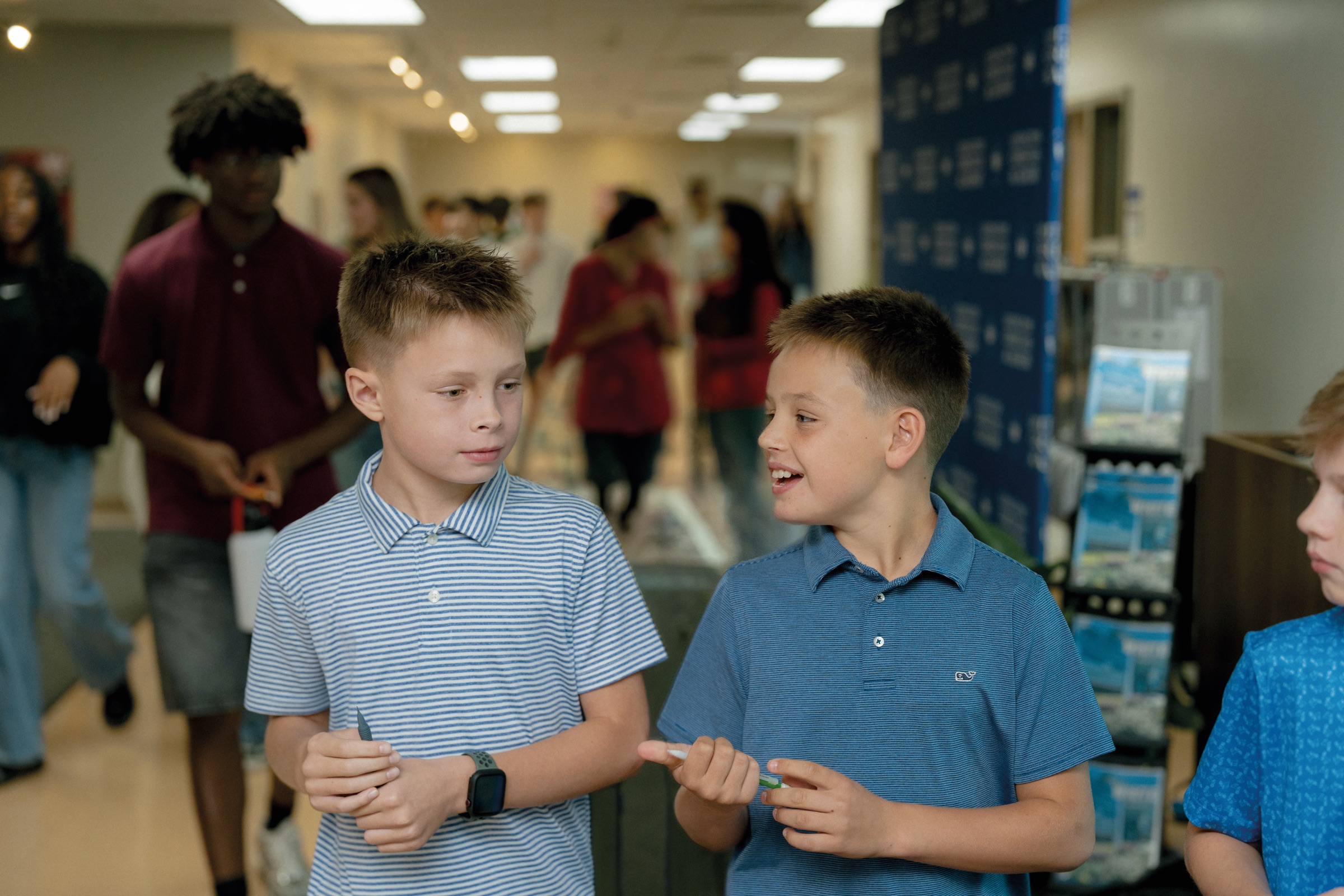 Two students talking in a busy hallway